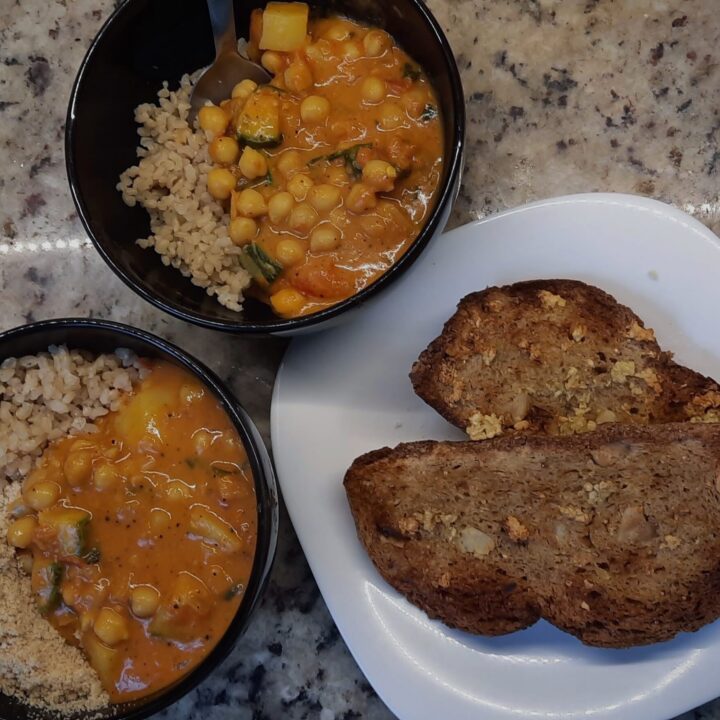 Dois bowls com arroz integral e curry de legumes.